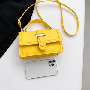 Vista dall'alto di una borsa gialla a motivo coccodrillo con smartphone per scala di misura