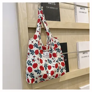 Détail du sac cabas en toile à fleurs avec motifs roses et étiquette tissée EMIS