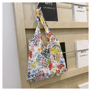 Détail du sac de shopping en toile à fleurs suspendu sur un support en bois minimaliste