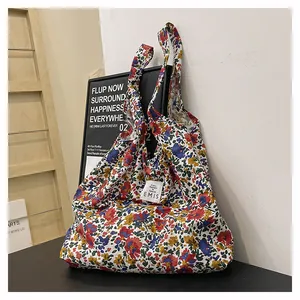 Détail du sac cabas EMIS en toile fleurie avec motifs colorés et étiquette de marque