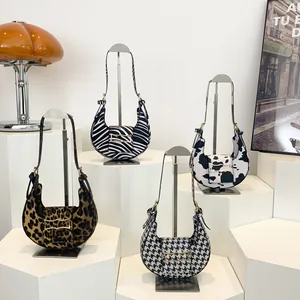 Hobo bags collection featuring leopard, zebra, cow, and houndstooth patterns with gold buckles