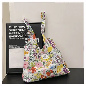Détail du sac cabas en toile à fleurs avec patch logo EMIS brodé et imprimé floral coloré