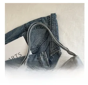 Detail view of grey pleated texture shoulder bag featuring silver butterfly metal ornament