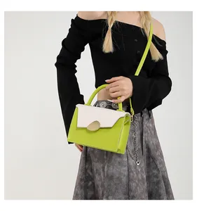 Close-up of lime green crossbody bag with white flap and gold clasp on a model