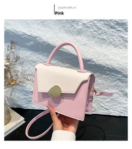 Detail view of pink and beige crossbody bag with gold metallic buckle and matte leather texture