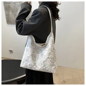 Gros plan d'un sac cabas en toile blanche avec broderie papillon en dentelle délicate
