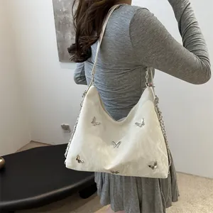 White faux leather shoulder bag with silver butterfly charms and chain strap detail