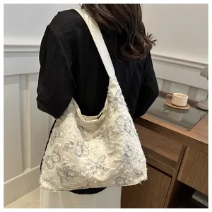 Détail du sac cabas en toile blanche avec motifs papillons bleus et bords effilochés