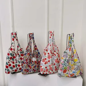 Sacs cabas en toile à fleurs avec logo EMIS sur des supports métalliques épurés