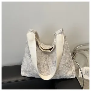 Gros plan du sac cabas en peluche grise avec motif papillon en dentelle et fermoir aimanté