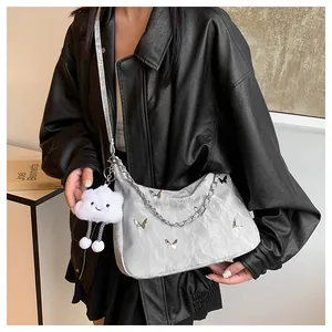 Borsa a mezzaluna argento metallizzato con ciondoli a farfalla indossata da una modella