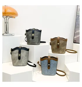 Detail view of retro bucket bags in four colors with gold twist-locks on white steps