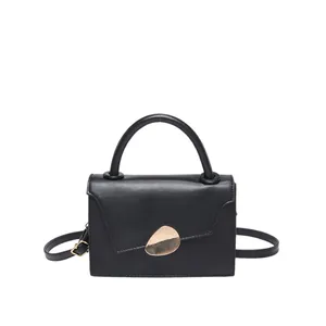 Modern black leather handbag with a unique pebble-shaped gold buckle and a top handle