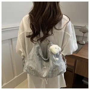 Detail of silver metallic cloud bag featuring butterfly buckles and plush cloud charm