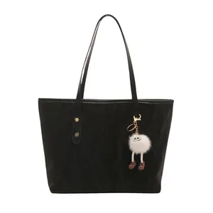 Minimalist black tote bag in textured material with cute white plush mascot pendant