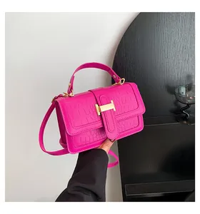 Dettaglio borsa fucsia in pelle coccodrillo con chiusura dorata a forma di H