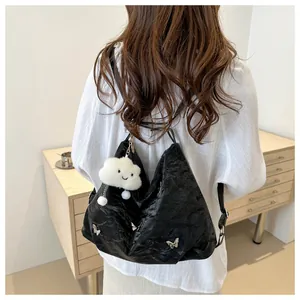 Detail of black pleated tote bag with silver butterfly clips and fluffy cloud charm