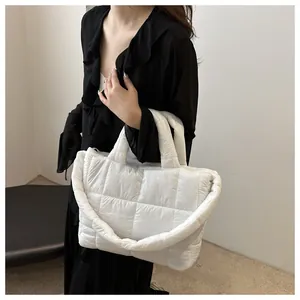 Detail of white quilted tote bag with large square stitching and soft padded texture
