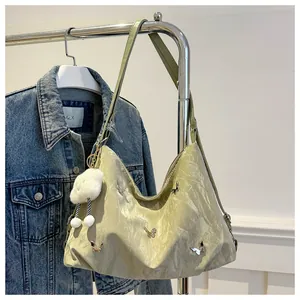 Detail of hobo bag with pleated texture, silver metal butterflies and plush pompom charm