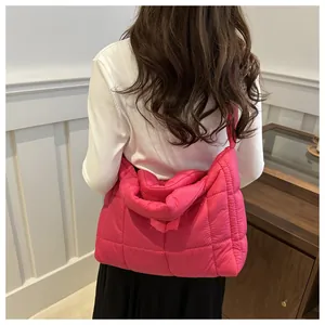 Detail of fuchsia quilted tote bag with soft texture and glossy finish shown from back