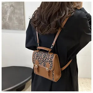 Brown leather backpack with leopard print flap shown from a rear back-view on a model