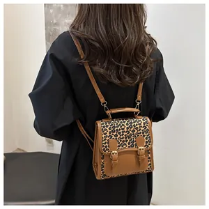 Detail view of brown leather backpack with leopard print panels and vintage gold buckles