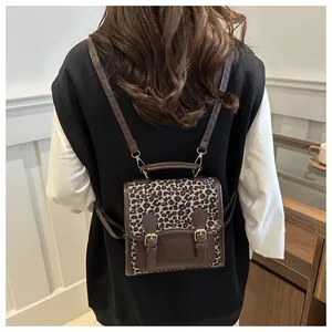 Detail view of stylish leopard print backpack with metal buckles shown on a model