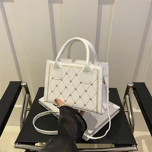 Sac à main blanc matelassé avec broderies de cœurs dorés et bandoulière amovible
