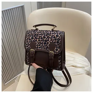 Detail of leopard print flap and brown faux leather stitching on small backpack