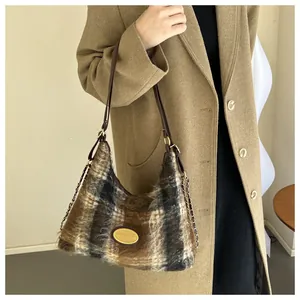 Détail du sac à bandoulière en peluche à carreaux marron avec chaîne dorée