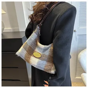Détail de la texture pelucheuse à carreaux et de la plaque sur le sac à bandoulière