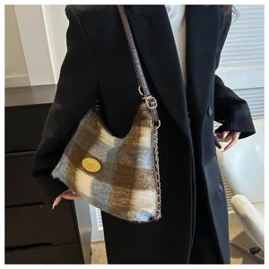 Détail du sac sous le bras en peluche à carreaux avec plaque dorée et bandoulière en cuir