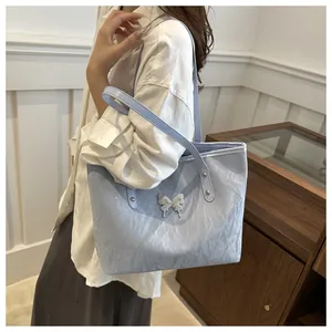 Detailed view of light blue pleated tote bag with a silver butterfly buckle for women