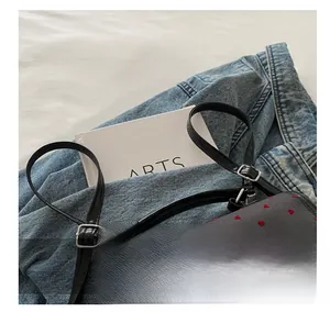 Close-up of adjustable leather shoulder straps on a grey fabric backpack with red heart prints