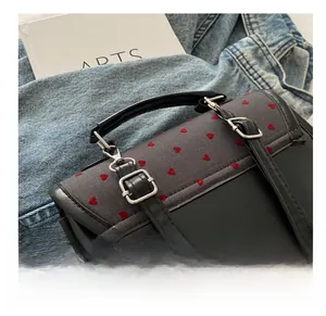 Detail showing grey fabric flap with red heart embroidery and silver metal buckle