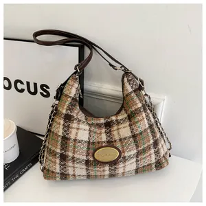 Détail du sac rétro à carreaux avec bandoulière en chaîne dorée et cuir