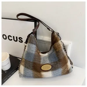 Vue détaillée du sac porté épaule à carreaux en peluche avec chaîne dorée et logo