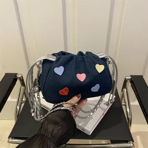 Blue denim heart drawstring bucket bag with colorful patches and silver chain strap