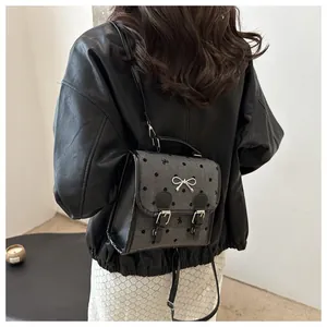 Polka dot backpack with bow detail shown on a model for a stylish casual look