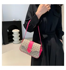 Nahaufnahme einer Vintage-Damenumhängetasche mit rosa Besatz und Monogrammmuster