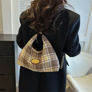 Sac hobo en toile à carreaux marron et jaune pour femme porté par un mannequin