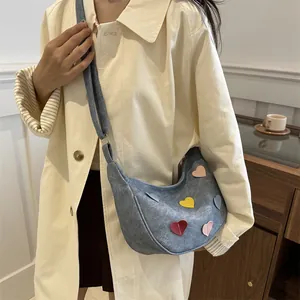 Chic crescent denim handbag with colorful leather hearts and wide shoulder strap