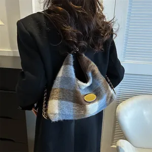 Sac hobo en fausse fourrure à carreaux bleu et marron avec chaîne dorée sur mannequin