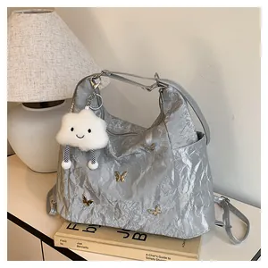 Sac fourre-tout gris argenté plissé avec breloques papillon dorées et pendentif nuage