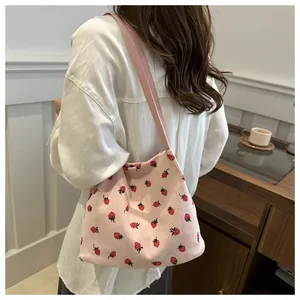 Détail du cabas en velours côtelé rose avec imprimé fraise et texture côtelée douce