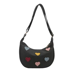 Minimalist black crescent moon bag with colorful heart patches and adjustable shoulder strap