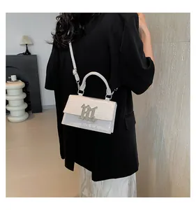 Nahaufnahme der weißen Handtasche mit Krokodilprägung und silberner Metallschnalle