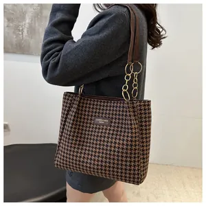 Détail du sac cabas pied-de-poule avec chaîne dorée et finitions élégantes en cuir marron