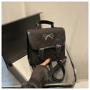 Detail of small black backpack with red heart patterns and silver bow metal buckle