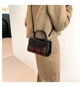 Vue détaillée d'un sac bandoulière à carreaux marron avec poignée et bandoulière noires